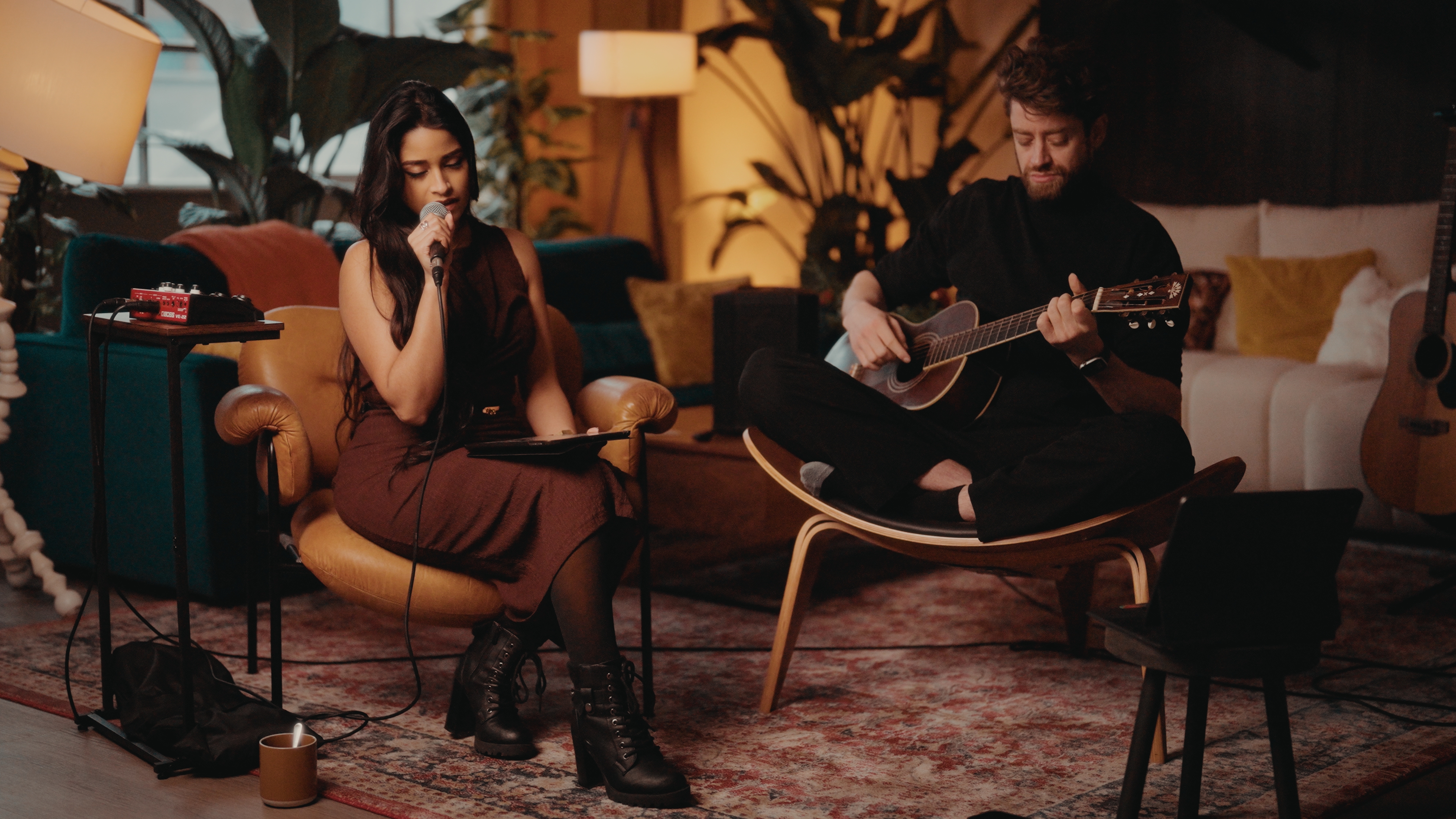 Acoustic live-music session with a vocalist and guitarist filmed in the warm-lit lounge at The Designer's Penthouse, Old Street London