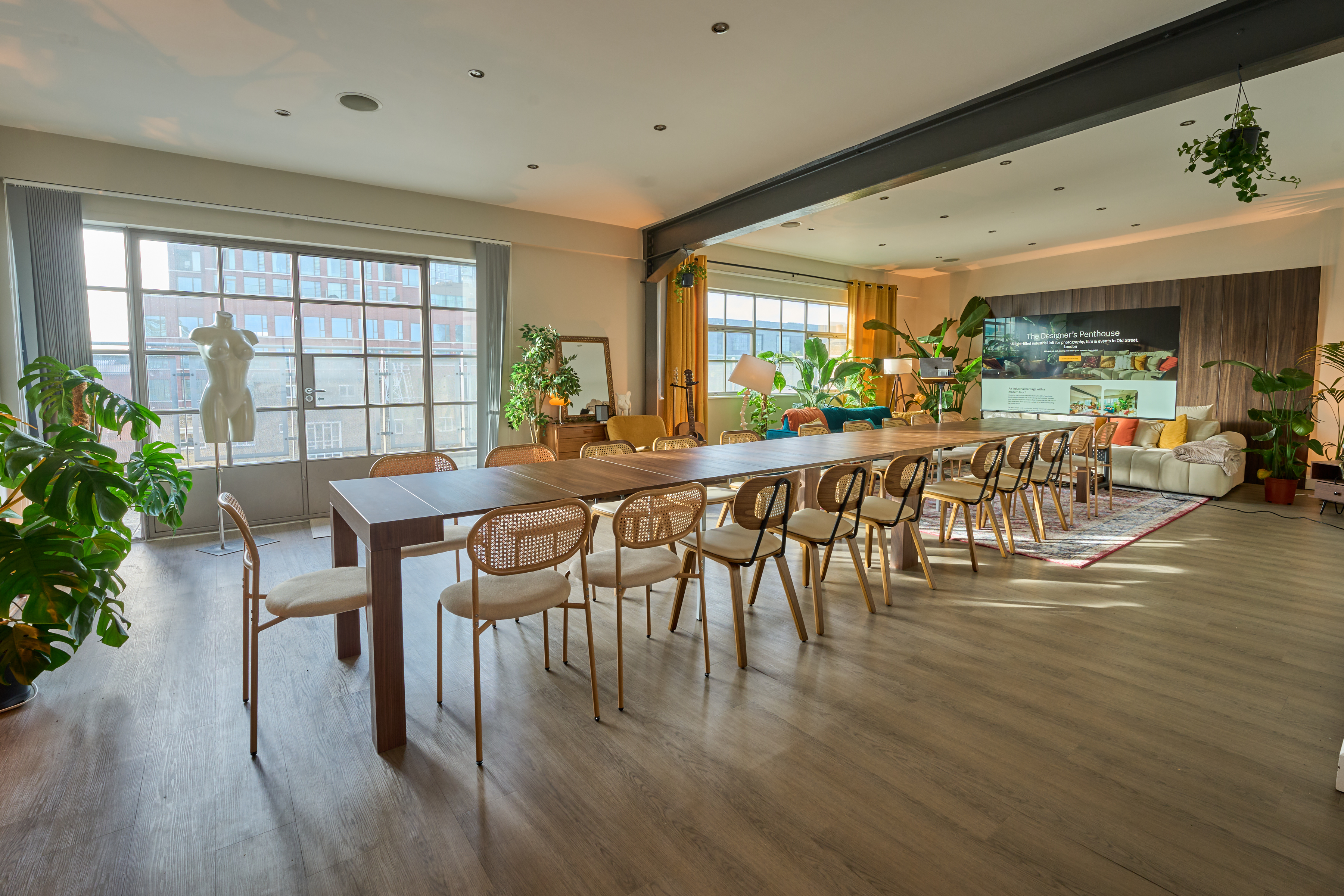The Designer's Penthouse 位于 Old Street, London 的论坛布局,含延展长桌、藤编座椅、大型演示屏幕与演讲台