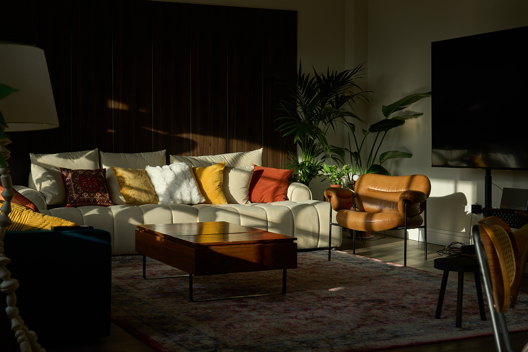 Spacious lounge area with mid-century furniture and natural south-facing light in the penthouse