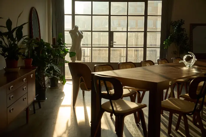 Sunlit dining area in a London penthouse with large windows, ideal for workshops and collaborative events.