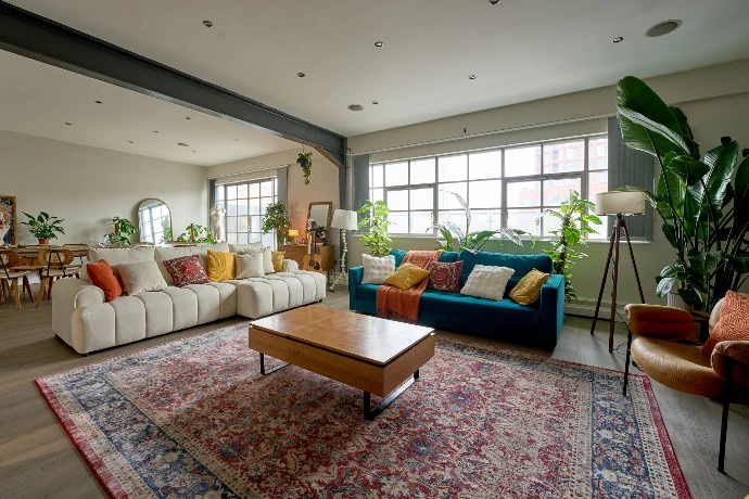 Wide-angle view of the main living space in a Shoreditch penthouse with natural light and modular furniture.