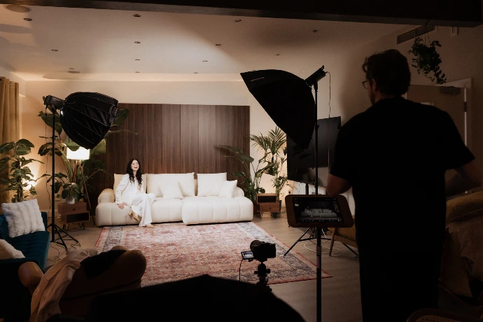 Professional video shoot setup in a Shoreditch penthouse, featuring lighting equipment, backdrop, plants and a styled living area for filming and content production.
